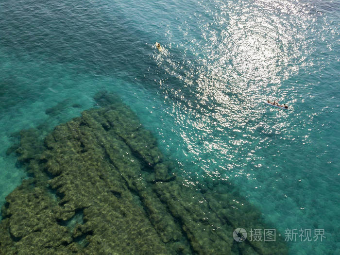 独木舟上透明的海上漂浮的水的鸟瞰图.泳客在海上.