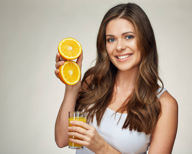 微笑的女士拿着桔子汁玻璃与半橙果