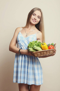 女孩拿着一篮新鲜蔬菜