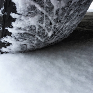 路上的雪覆盖着的汽车轮胎的特写