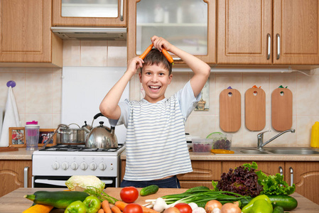 儿童男孩玩胡萝卜。家用厨房内部与 fru