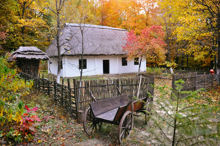 古代的茅草屋,秸杆屋顶和木制手推车照片