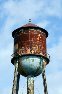 旧的生锈的水塔对着蓝天