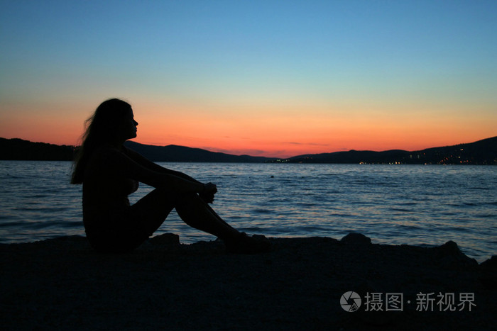 美丽的女人坐在海滩上