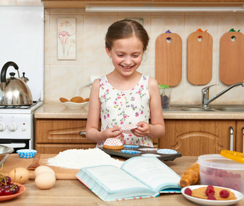 女孩烤饼干的香味。家用厨房室内。健康食品的概念