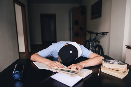 学生睡着了做作业在书和笔记本在他的房间.教学在家里.在桌旁睡着照片