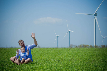 爸爸和儿子挥舞着他们的手给风力发电机