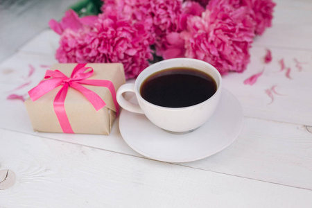 一杯咖啡 粉红牡丹图案及礼品盒木制背景