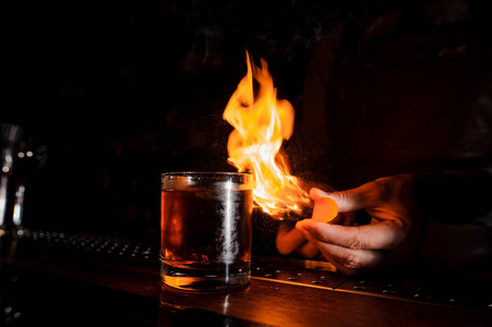 酒保使火焰上方的鸡尾酒