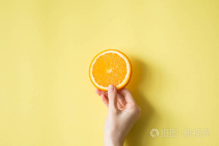 手拿着橙色黄色背景食品概念
