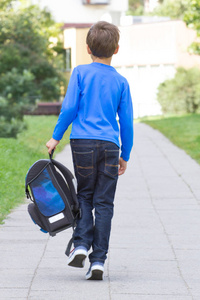 小男孩与一个背包去上学。后视图