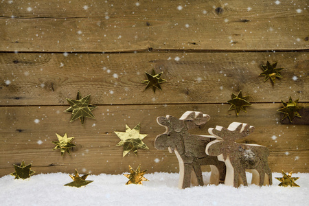 两个木制手工驯鹿与金色的星星背景上
