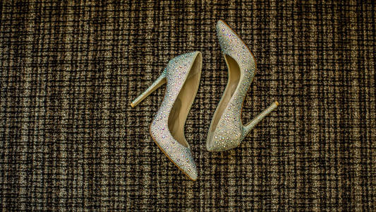 婚礼鞋。鞋子。新娘的婚礼配件。新娘的鞋子在沙发上的照片。婚礼费用
