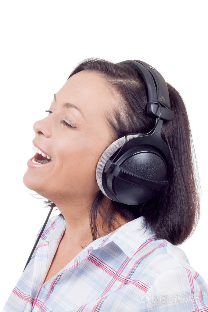 快乐的微笑美丽的年轻女子听音乐与headpho