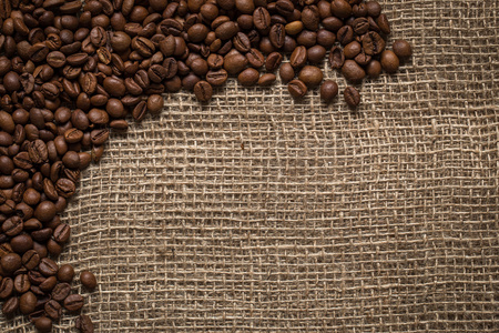 麻布背景上分散的咖啡豆