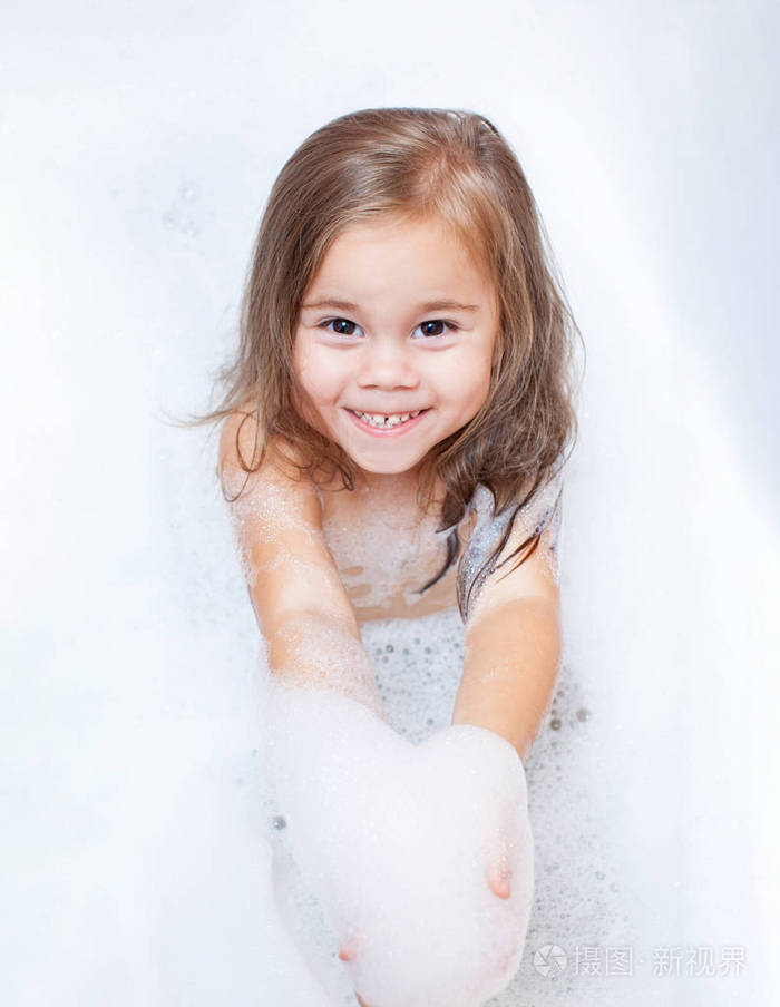 快乐的小女孩正在洗澡的泡沫
