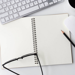 现代白色办公杯咖啡 笔记本和其他用品，电脑笔记本桌子顶部。与复制空间白色背景上的顶视图。顶视图，平躺