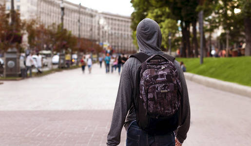 在大城市的孤独年轻人走在街上的一个大城市照片