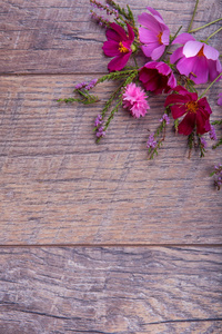 一束粉红色和紫色的花朵科斯梅亚或宇宙用丝带在质朴的木板上。复制空间。母亲，情人节，女性，结婚那天概念