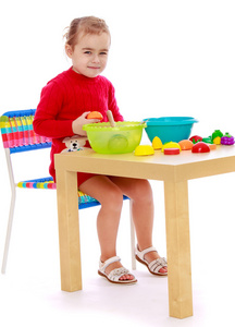微笑着坐在桌子旁玩耍的孩子