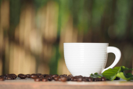 白咖啡杯子与咖啡种子和树叶