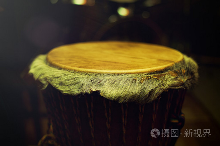 非洲非洲鼓鼓与皮革椎板与美丽的头发在美丽的tyellow光与黑暗的背景