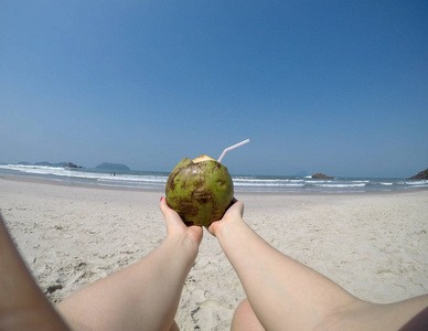 女孩抱着椰子在沙滩上，巴西