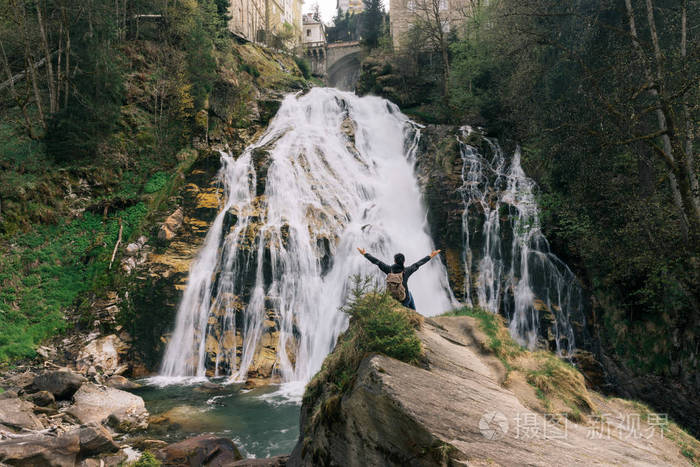 奥地利。加施。在阿尔卑斯山脉瀑布的女孩