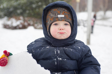 一个小小的孩子，看起来是雪或冰碎片。一个孩子玩雪