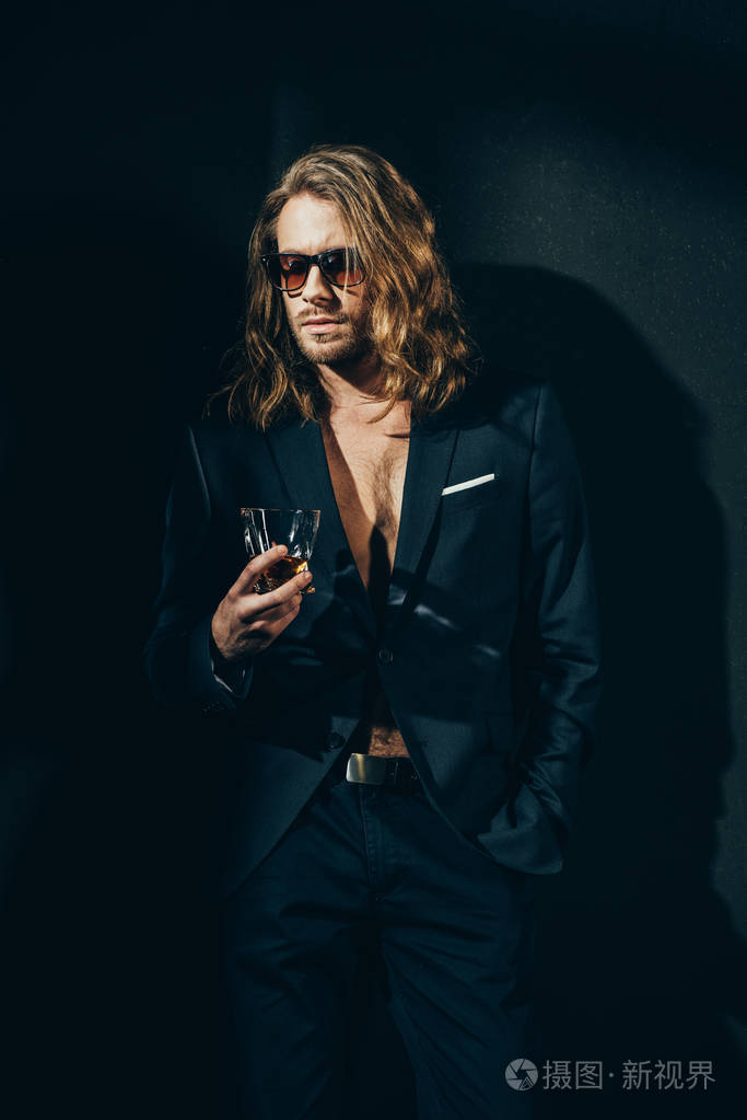 穿着西装喝威士忌酒的男人