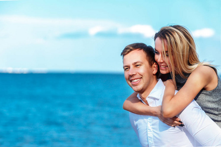 幸福的夫妇的海面背景。快乐年轻的浪漫的情侣在爱情中得到乐趣 l 海滩上，美丽的夏日