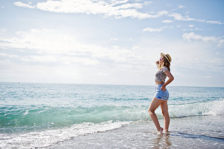 漂亮的模特在海边沙滩上放松，穿上牛仔裤 sho