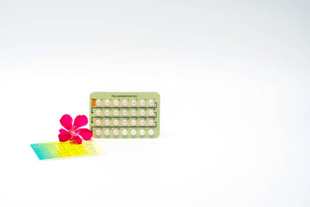 与粉红色的花，白色背景上的避孕药。家庭计划概念
