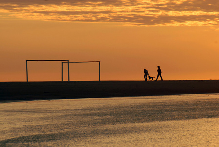 一对夫妇黎明时分在海滩上跑步图片