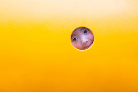 可爱的亚洲男孩玩和在黄色隧道在 playg 中微笑