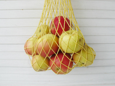 网格袋黄色和红色的苹果在网袋,黄色网格袋-股票图像照片