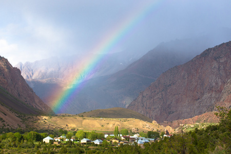 彩虹在山区的村庄。景观