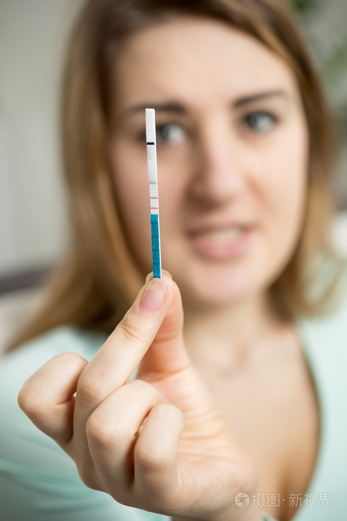 担心的女人正看着妊娠实验阳性的肖像照片-正版商用图片00rhgj-摄图新