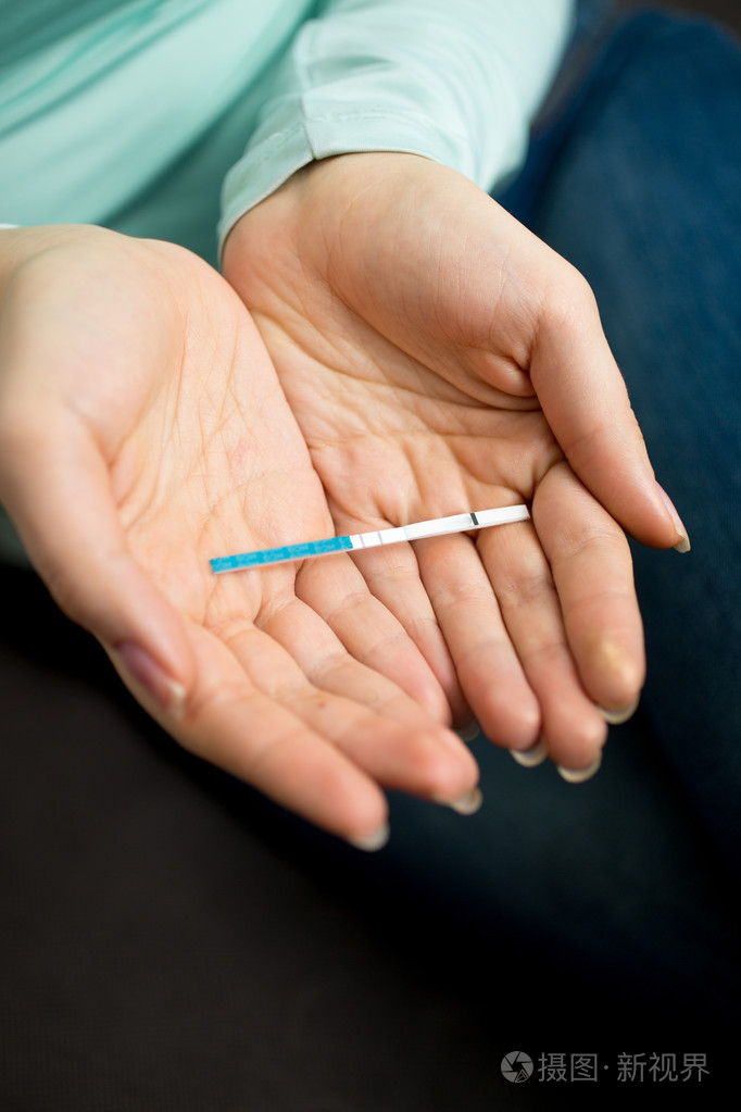 手里拿着阳性怀孕的女人