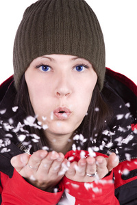 女人吹着柔软的白色雪花