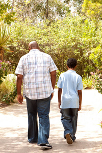 非裔美国人父亲和儿子散步后视图