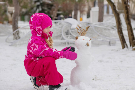 快乐的孩子女孩玩堆雪人