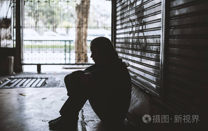 无家可归的女人坐在街边