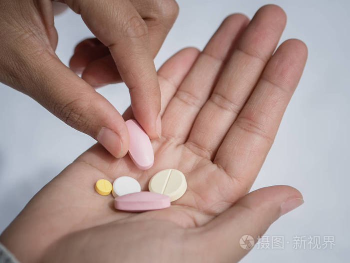 特写女人手抱着一颗药丸.医疗保健,医疗补助
