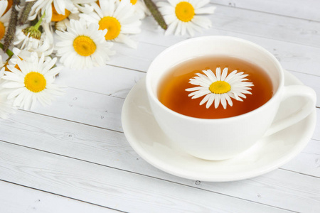一杯甘菊茶和蜂蜜白色木制背景上