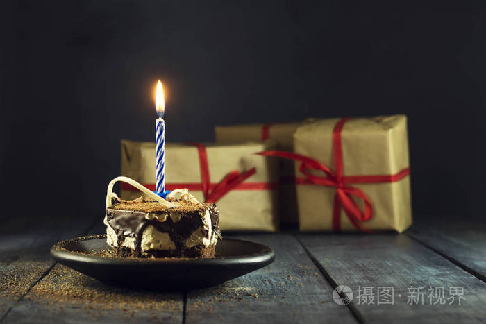 用一支蜡烛和礼物的巧克力蛋糕.生日快乐,卡.节日贺卡