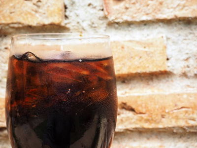 用冰块在砖墙附近的透明玻璃上品尝可乐