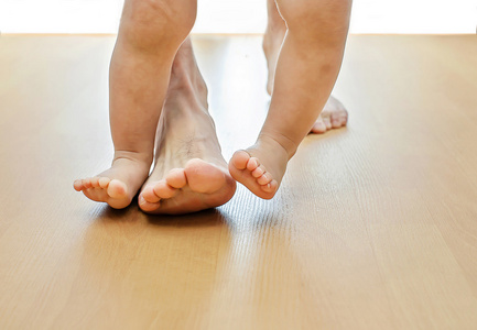 婴儿学走路在城市公园可爱的宝宝学习如何走路与母亲呆在家里宝宝学