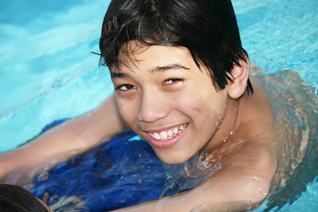 小男孩在游泳池游泳照片