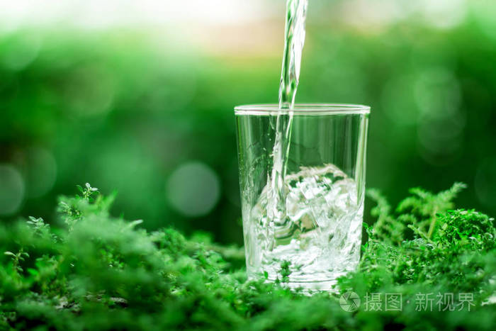 一杯清凉新鲜水天然绿色背景